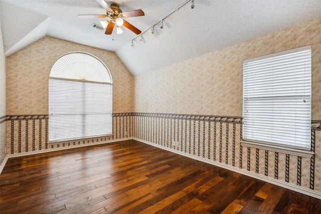 unfurnished room featuring a textured ceiling, hardwood / wood-style flooring, ceiling fan, and lofted ceiling