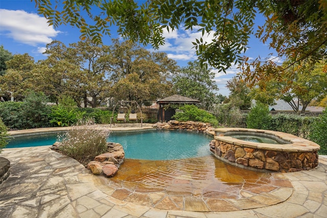 view of swimming pool with a gazebo and an in ground hot tub