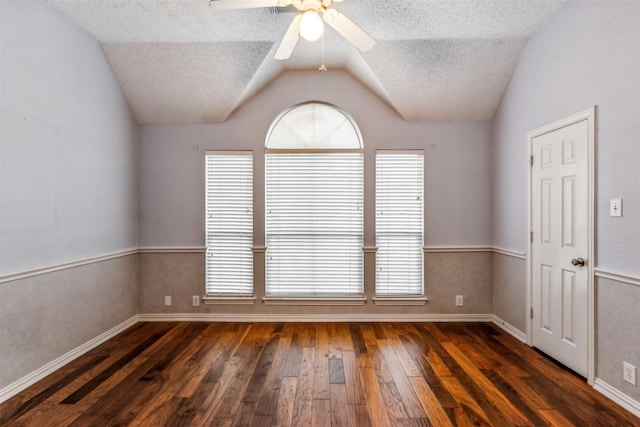 unfurnished room featuring a textured ceiling, ceiling fan, dark wood-type flooring, and lofted ceiling