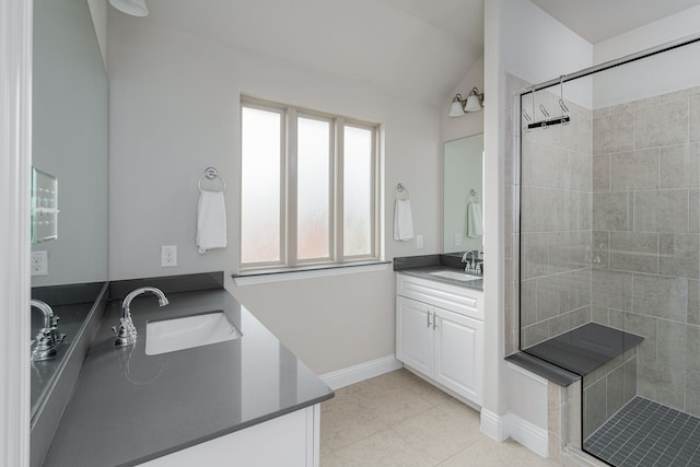 bathroom featuring tile patterned floors, vanity, tiled shower, and lofted ceiling