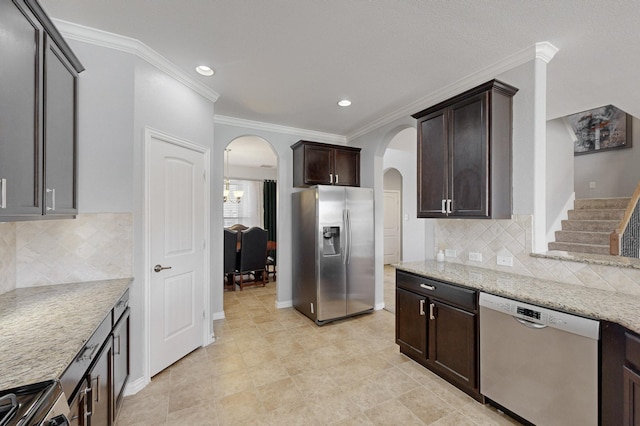 kitchen featuring light stone countertops, stainless steel appliances, backsplash, dark brown cabinets, and ornamental molding