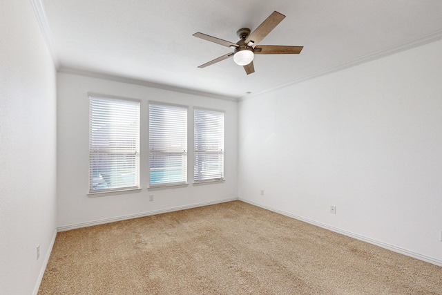 carpeted spare room featuring ceiling fan and crown molding