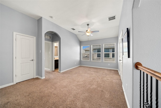 empty room with ceiling fan, a healthy amount of sunlight, light colored carpet, and lofted ceiling