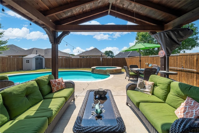 view of pool featuring a storage shed, an outdoor hangout area, an in ground hot tub, and a patio