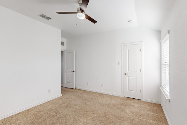 spare room featuring light colored carpet, ceiling fan, and lofted ceiling