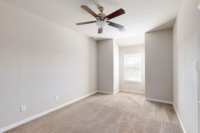 carpeted empty room featuring ceiling fan