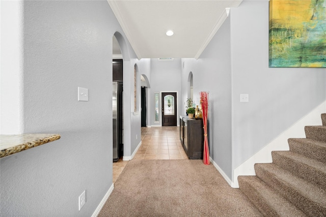 hallway with light tile patterned floors and crown molding