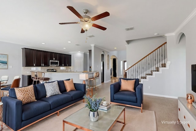 living room featuring crown molding, sink, and ceiling fan