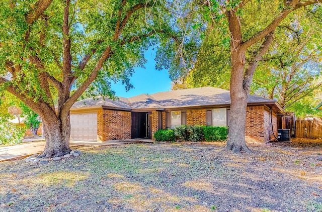 ranch-style home with a garage and central AC