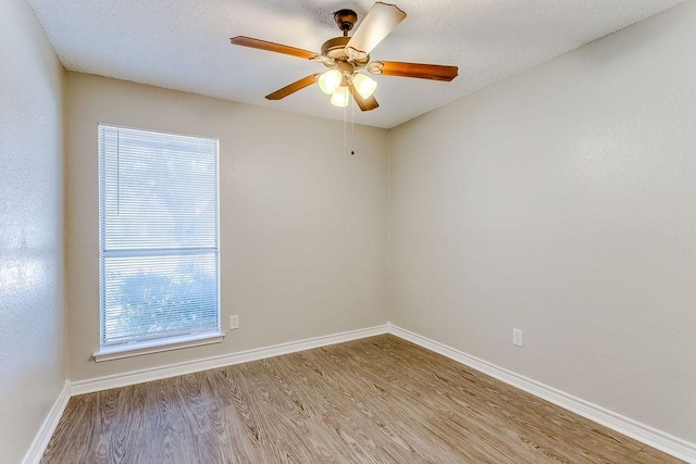 empty room with a textured ceiling, light hardwood / wood-style flooring, and ceiling fan