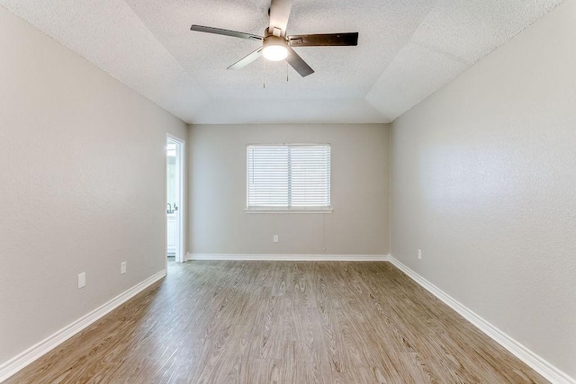 empty room with ceiling fan, a textured ceiling, and light wood-type flooring