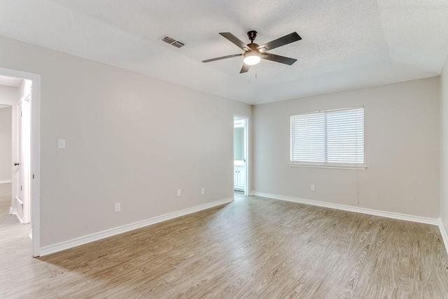 spare room with ceiling fan, light hardwood / wood-style floors, and a textured ceiling