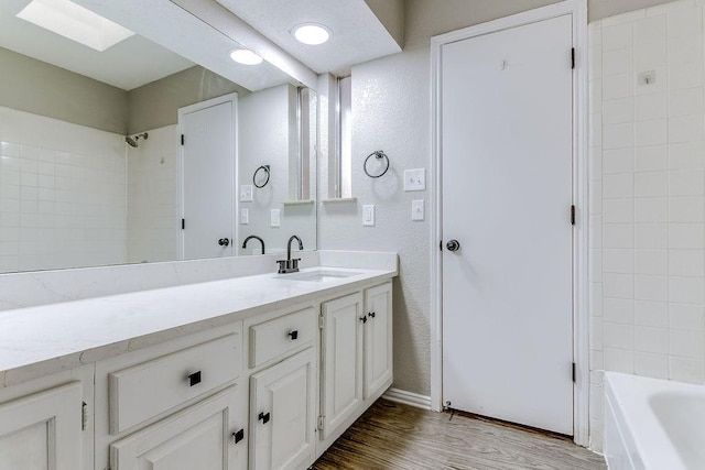 bathroom featuring vanity, hardwood / wood-style flooring, and tiled shower / bath