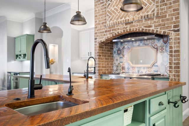 kitchen with wood counters, green cabinets, and sink