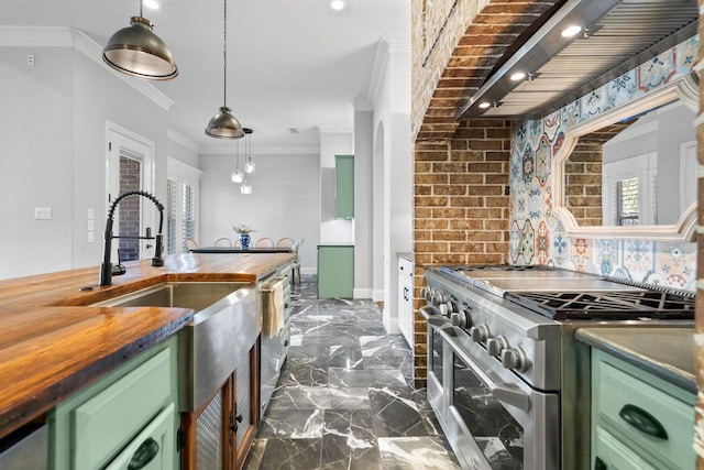 kitchen with ornamental molding, hanging light fixtures, green cabinetry, and appliances with stainless steel finishes