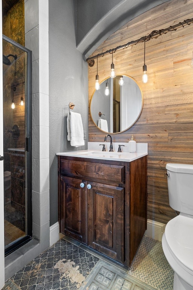 bathroom with vanity, toilet, walk in shower, and wooden walls