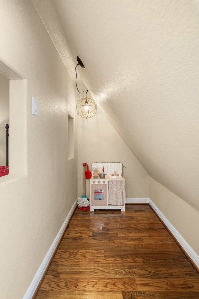 additional living space featuring dark hardwood / wood-style floors and vaulted ceiling