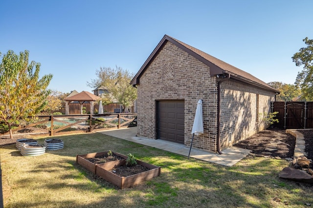 view of home's exterior with a gazebo, a garage, an outbuilding, and a lawn