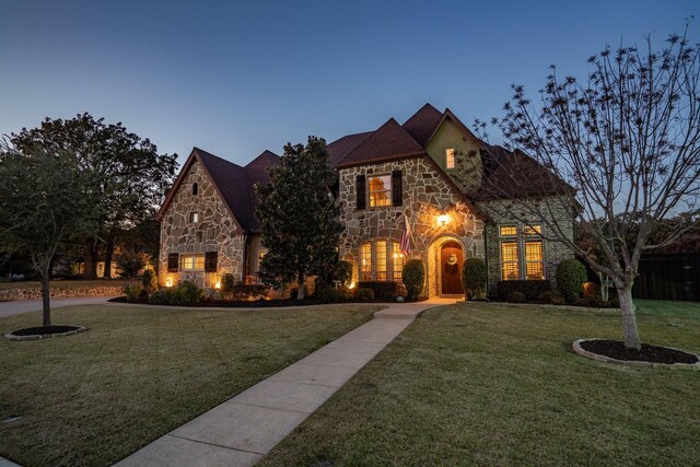 english style home featuring a lawn