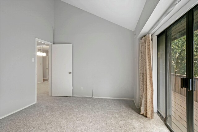 carpeted empty room featuring lofted ceiling