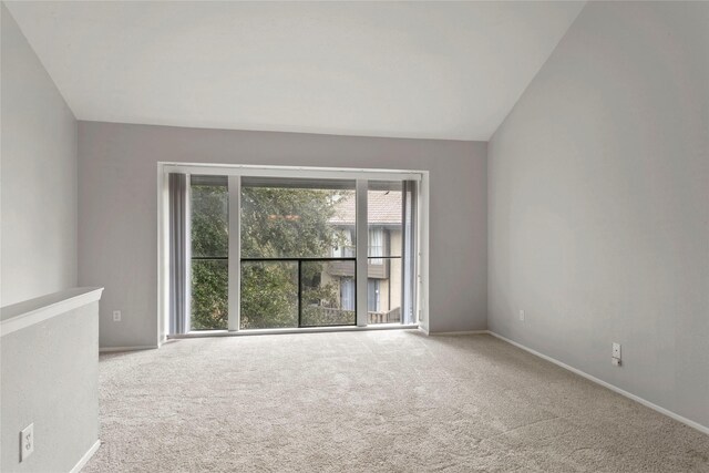 unfurnished room featuring carpet flooring and lofted ceiling