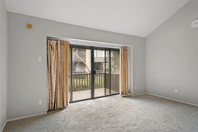 carpeted empty room featuring lofted ceiling