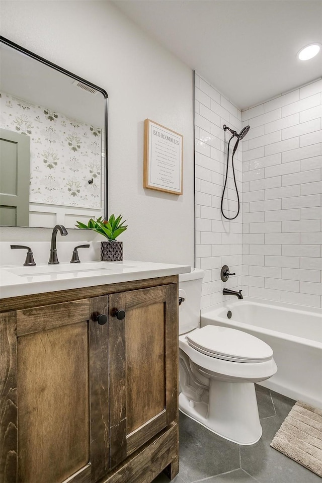 full bathroom featuring vanity, tiled shower / bath combo, toilet, and tile patterned flooring