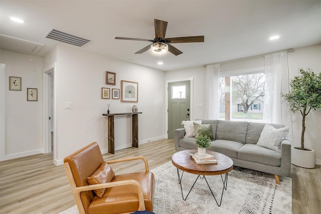 living room featuring ceiling fan and light hardwood / wood-style flooring