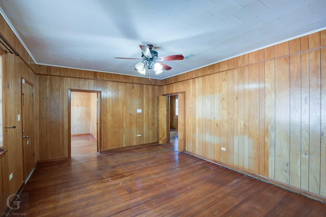 unfurnished room with wooden walls, ceiling fan, and dark hardwood / wood-style flooring