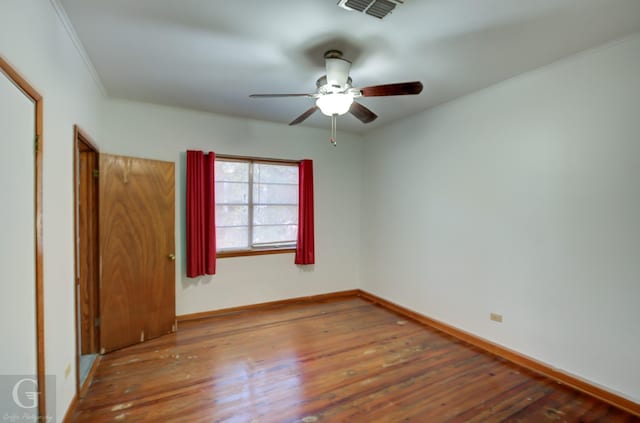 unfurnished bedroom featuring dark wood-type flooring, ornamental molding, and ceiling fan