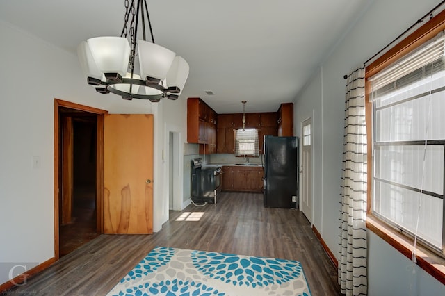 kitchen with stainless steel electric range oven, black fridge, dark hardwood / wood-style floors, and decorative light fixtures