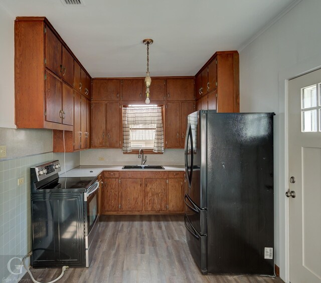 kitchen featuring black electric range oven, fridge, sink, tasteful backsplash, and light hardwood / wood-style floors