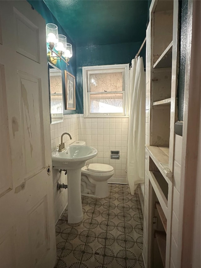 bathroom featuring tile patterned flooring, a shower with curtain, toilet, and tile walls