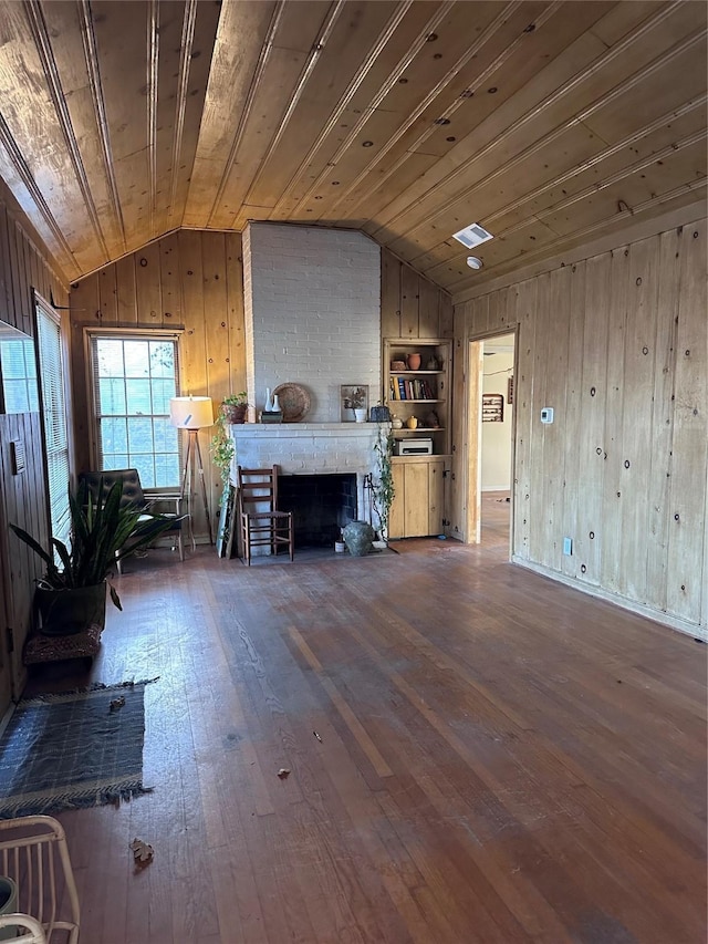 unfurnished living room with built in shelves, dark wood-type flooring, wooden ceiling, vaulted ceiling, and a fireplace