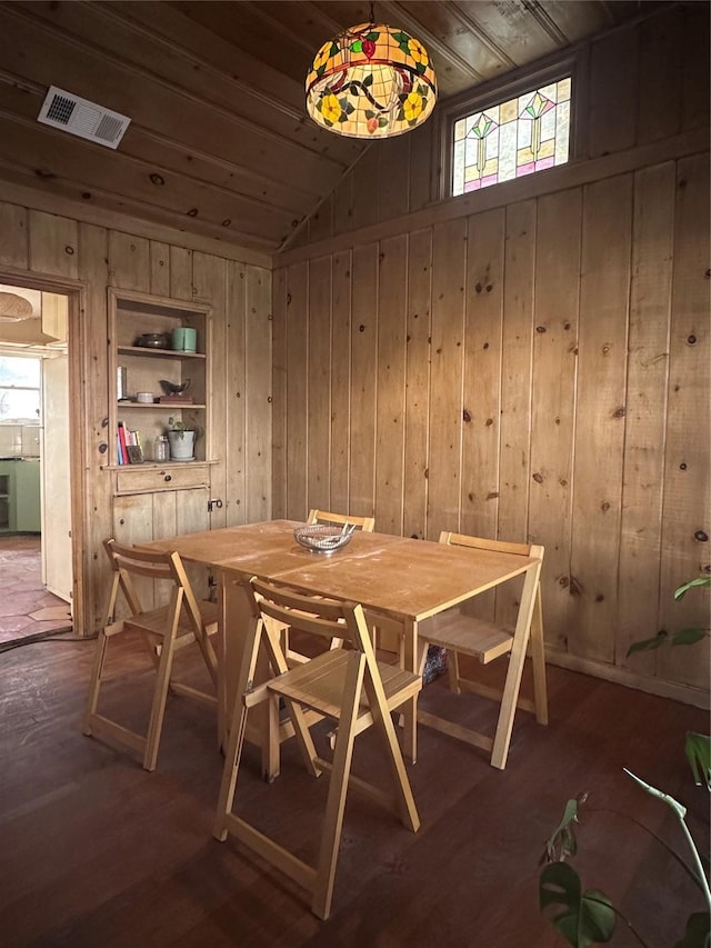 dining room with wooden ceiling, built in features, dark hardwood / wood-style floors, wood walls, and lofted ceiling