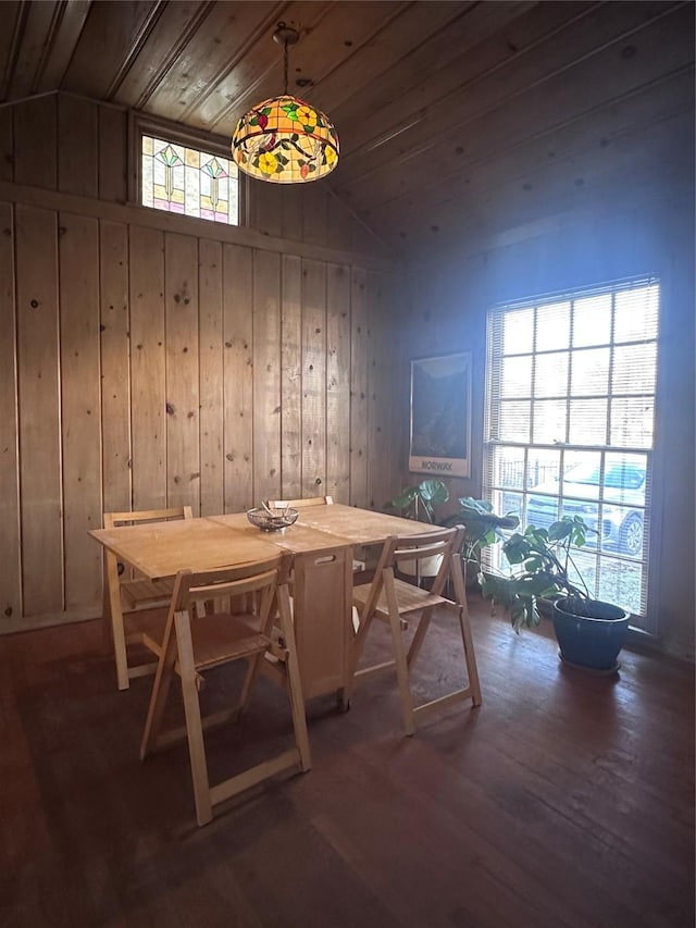 dining room featuring wooden walls, dark wood-type flooring, wooden ceiling, and lofted ceiling