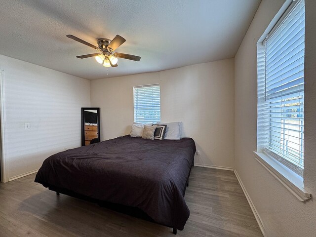 bedroom featuring a textured ceiling, ceiling fan, and dark wood-type flooring