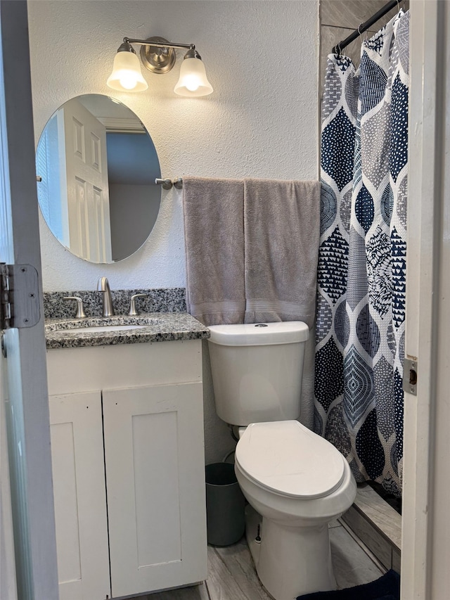 bathroom with a shower with shower curtain, wood-type flooring, vanity, and toilet