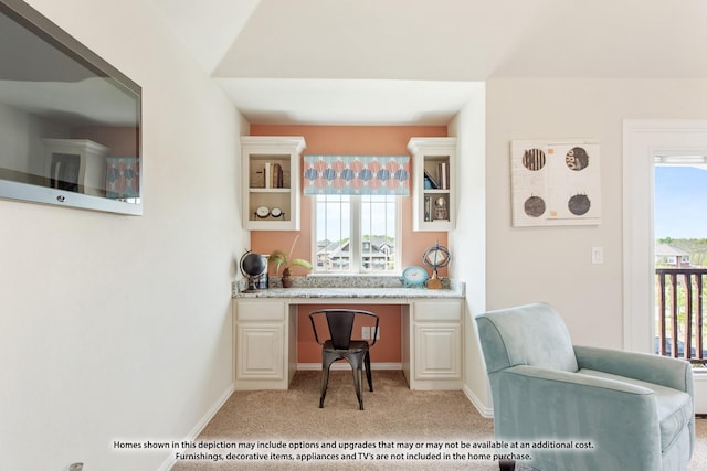 office area featuring plenty of natural light, light colored carpet, and built in desk