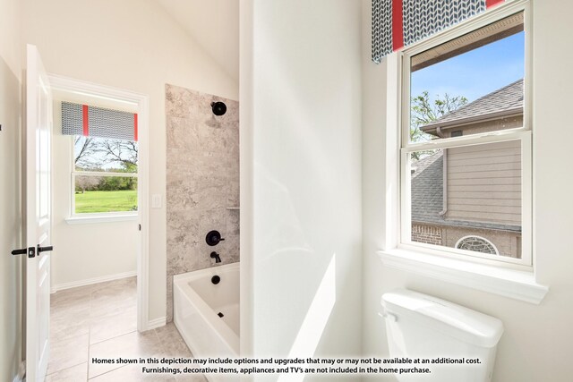 bathroom featuring tile patterned flooring, tiled shower / bath combo, toilet, and lofted ceiling