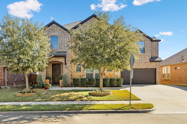 view of property hidden behind natural elements with brick siding, an attached garage, and driveway