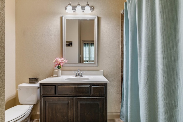 bathroom featuring a shower with shower curtain, vanity, and toilet