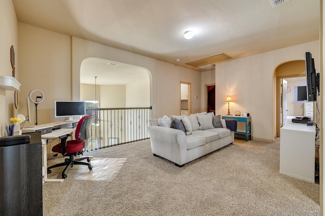 carpeted living room featuring a textured ceiling