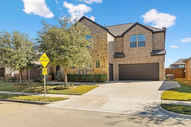 view of front of house with brick siding, an attached garage, concrete driveway, and fence