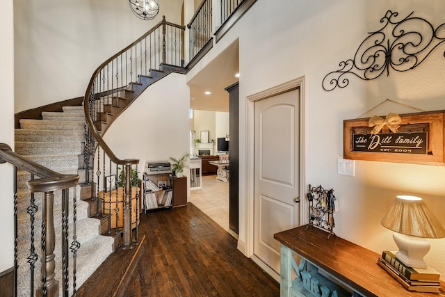 foyer entrance with wood-type flooring and a high ceiling