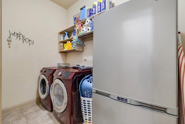 laundry room featuring washer and clothes dryer and light tile patterned flooring