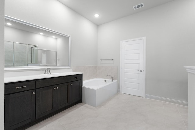 bathroom with tile patterned flooring, vanity, and separate shower and tub