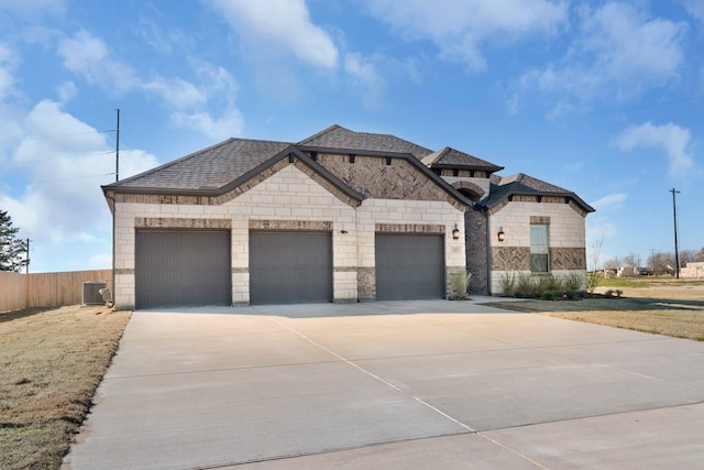 view of front of property featuring cooling unit and a garage