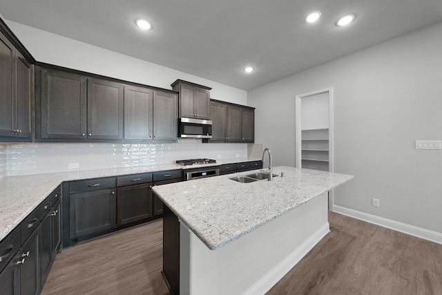 kitchen with a kitchen island with sink, wood-type flooring, sink, and appliances with stainless steel finishes