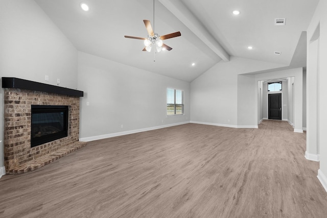 unfurnished living room featuring vaulted ceiling with beams, ceiling fan, a brick fireplace, and light wood-type flooring